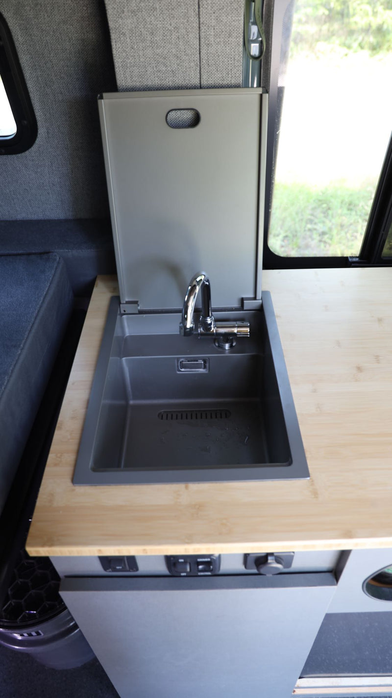  and practical overhead storage for adventure travel.|This customized gray Mercedes Sprinter **camper van** — photo 8