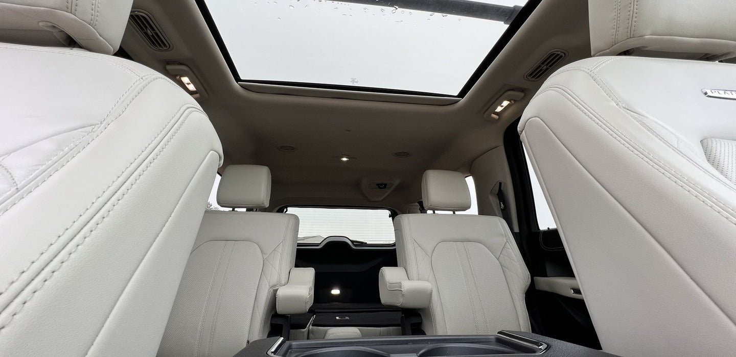 Plush white leather interior of a spacious vehicle with a panoramic roof, offering comfort for any journey, including rv rental trips.