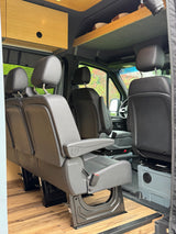 Spacious rv rental interior features comfortable passenger seating, wood flooring, and overhead storage for your journey.