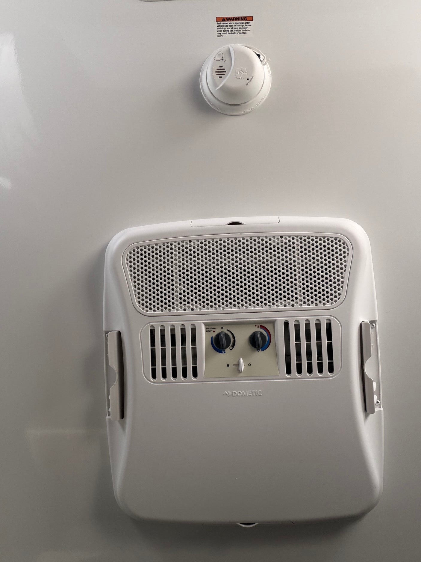 RV rental interior: Dometic AC unit with heat/cool controls and a smoke alarm, crucial for travel trailer safety.