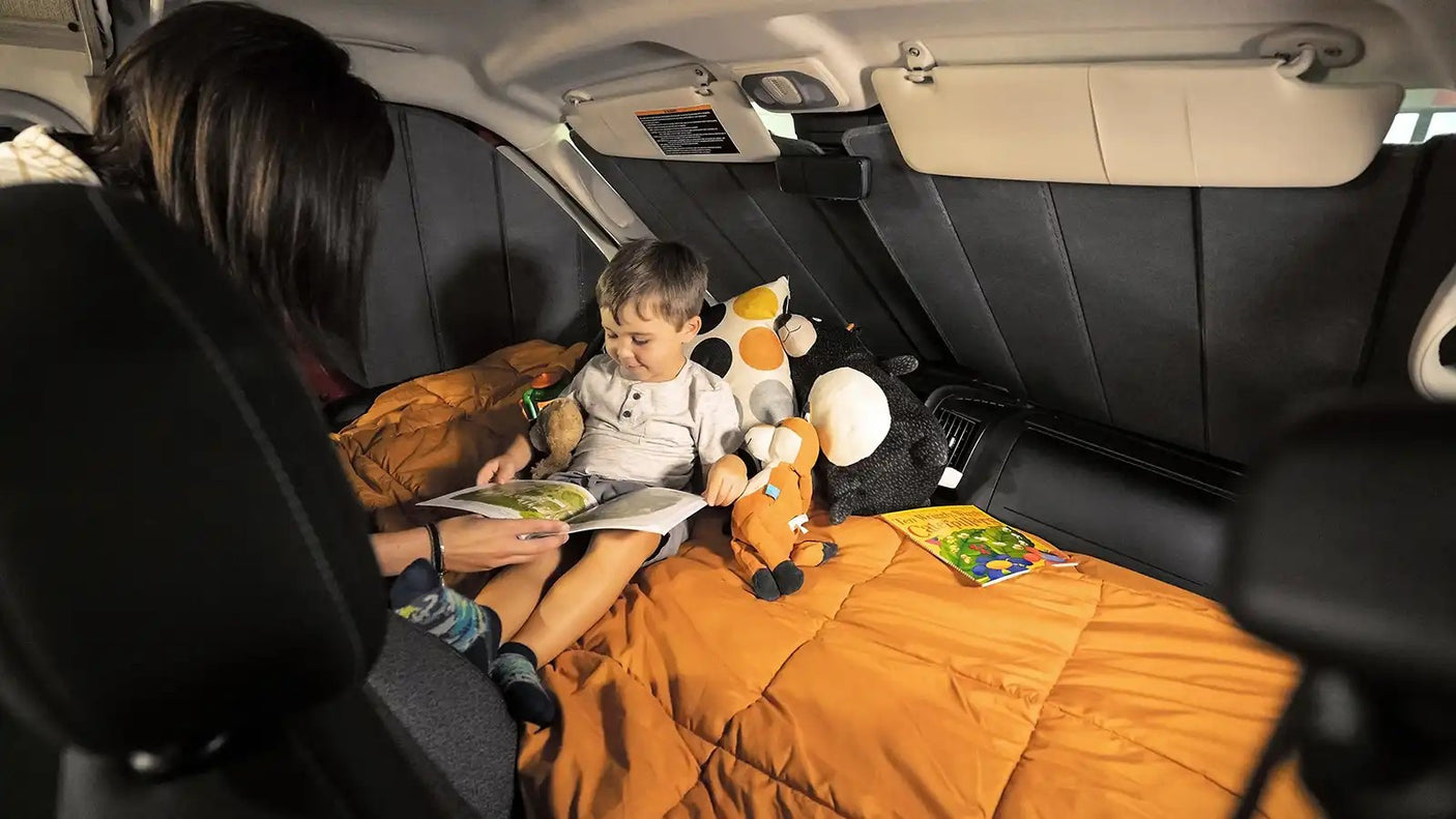 Mom reads to her son in a cozy RV rental setup, perfect for family camping and travel adventures.