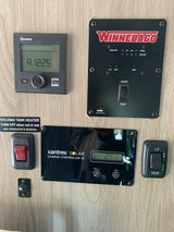 RV rental: A control panel showing Truma heater, Winnebago tank/battery monitor, Xantrex solar controller, and utility switches.