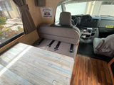 Step inside this RV rental! View of the living area with dinette seating, table, and the front dashboard.