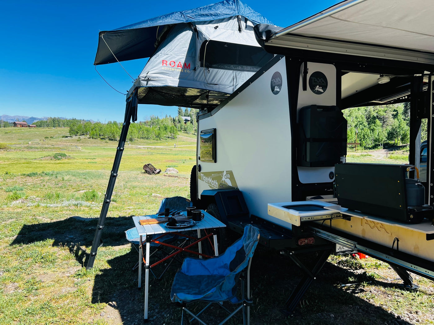 ROAM rooftop tent on a Taxa TigerMoth rv rental, with a mobile kitchen setup for outdoor camping in a scenic landscape. — photo 8