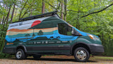 Adventure-ready **RV rental** van with a scenic mural & sponsor logos, parked amidst green trees.