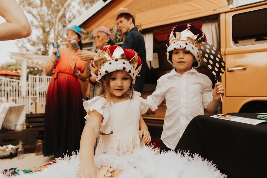 Children in king/queen crowns play at a lively outdoor party, with an RV rental in the background. Fun games and karaoke! — photo 12