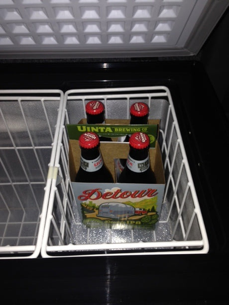 Chilled Uinta Detour beer, featuring an RV on its label, inside a cooler. Ideal for your RV rental journey.