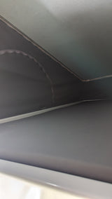 RV rental interior: Looking up at the ceiling and dark grey fabric walls with trim. A hanging zipper suggests a pull-down blind.