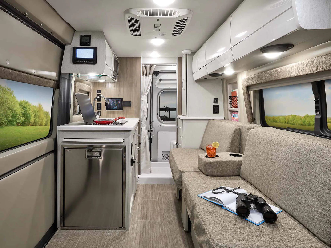 RV rental's modern mobile living space: compact kitchen, cozy lounge, and scenic views for travel.