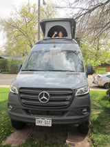 Child waves from this pop-top Mercedes-Benz Sprinter RV rental, a camper van ready for adventure.