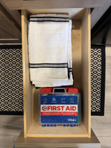 RV rental drawer: folded towels and a 110-piece multi-purpose first aid kit, ready for home or travel.