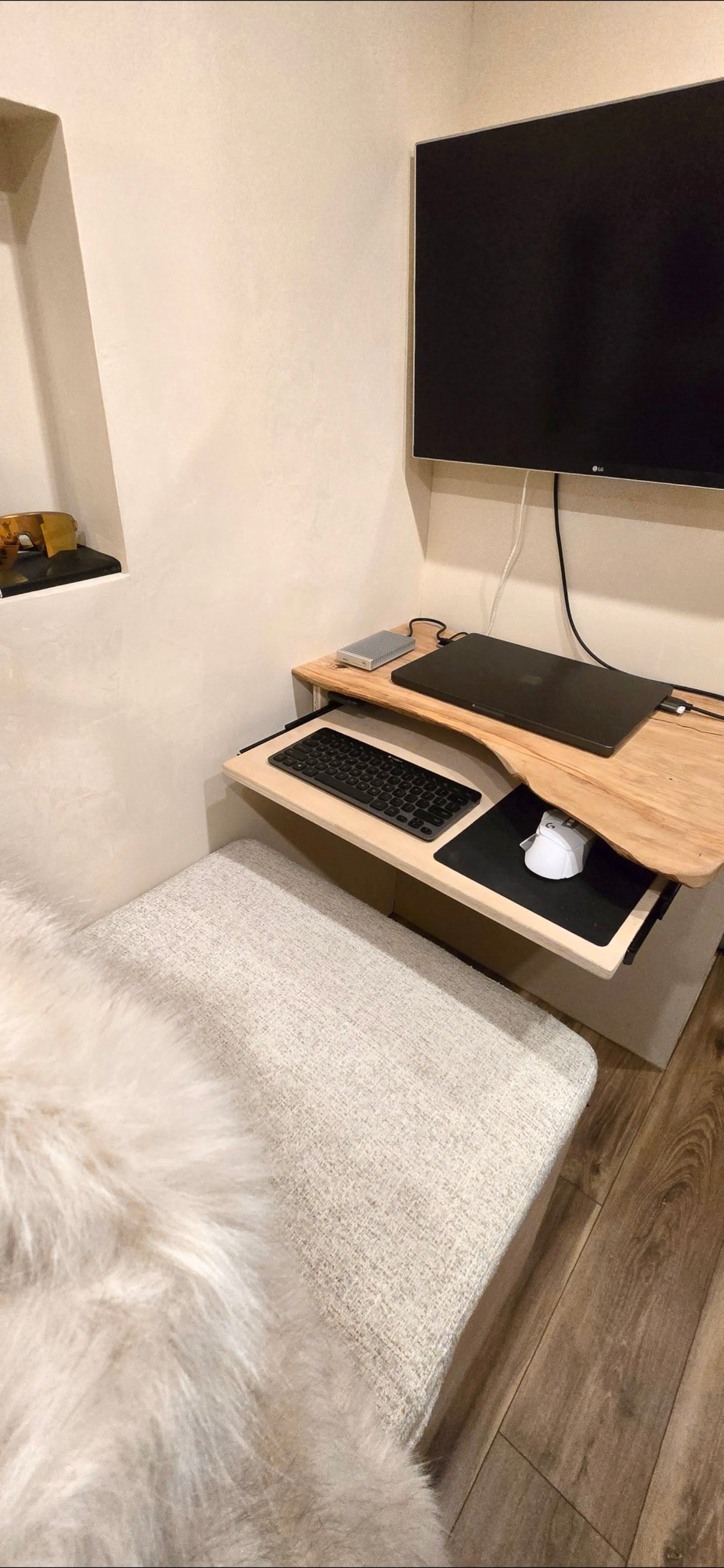 This RV rental features a compact workspace with a TV, laptop, pull-out keyboard/mouse tray, and upholstered seating.