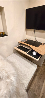 This RV rental features a compact workspace with a TV, laptop, pull-out keyboard/mouse tray, and upholstered seating.