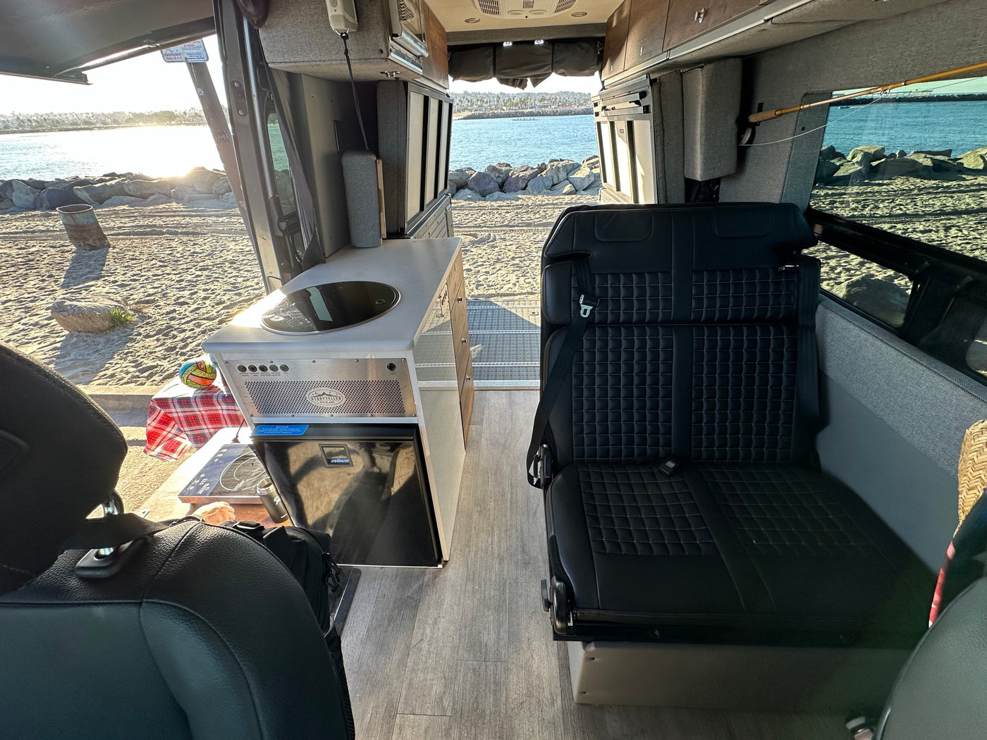 Explore this RV rental's spacious interior with a Storyteller kitchen, comfortable seating, and beach views. — photo 2