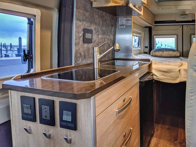  with bikes on the back for your next adventure.|Gray rv rental with pop-top parked in a green forest campsite — photo 5
