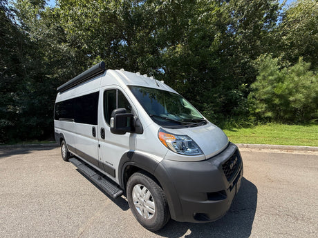 Bright day showcasing a sleek gray Airstream camper van, perfect for your next rv rental adventure, parked on asphalt.