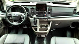 RV rental interior showing a modern Ford van dashboard with touchscreen, steering wheel, and custom switches.