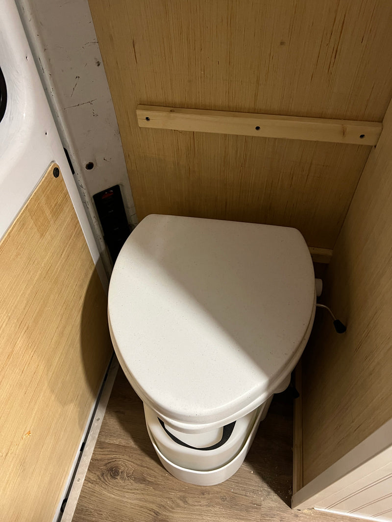 RV rental: Composting toilet in a compact van conversion, featuring wood paneled walls and vinyl flooring. — photo 4