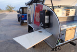 An rv rental teardrop trailer with a Coast Guard theme and an outdoor kitchen, ready for adventure with a Jeep.