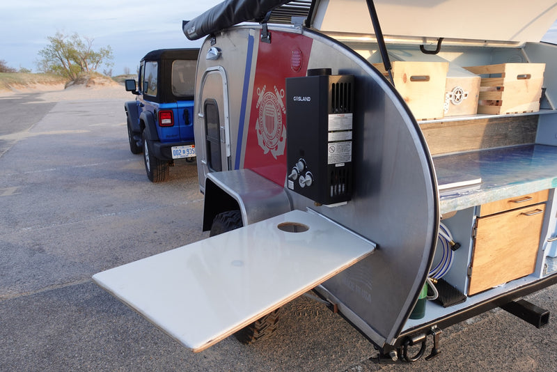 An rv rental teardrop trailer with a Coast Guard theme and an outdoor kitchen, ready for adventure with a Jeep. — photo 6