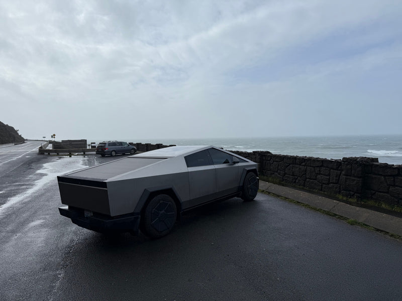 Sleek Tesla Cybertruck on a wet coastal road overlooking a stormy ocean. Forget an RV rental, this is modern exploration. — photo 15