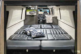 Spacious camper van interior, perfect for your next RV rental adventure. Features a large bed, kitchen, and TV.