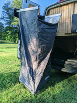 RV rental's Joolca outdoor shower privacy tent extended from the van's rear, ready in a grassy field.