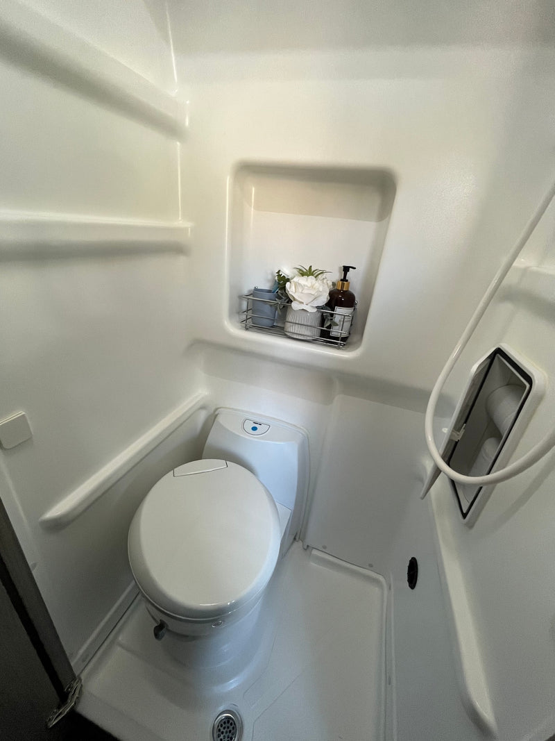 This RV rental wet bath offers a compact toilet, shower, and integrated shelf with toiletries. — photo 15