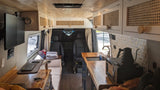 RV rental van interior with a bright, custom-built design. Features a wood-paneled ceiling, modern kitchen, and cozy living area.