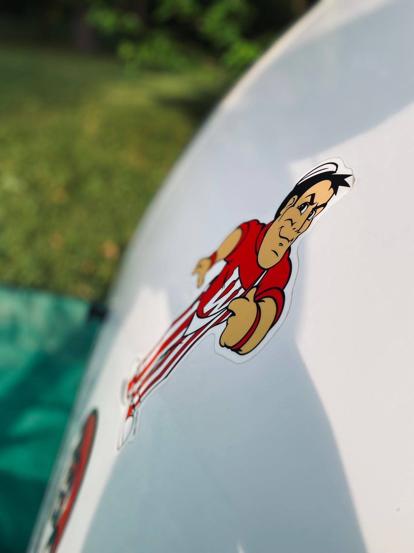 Close-up of a vibrant mascot sticker on an RV rental, depicting a running figure against an outdoor backdrop.