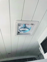 RV rental: White paneled ceiling with a roof fan, complete with directional airflow controls. Recessed light visible.