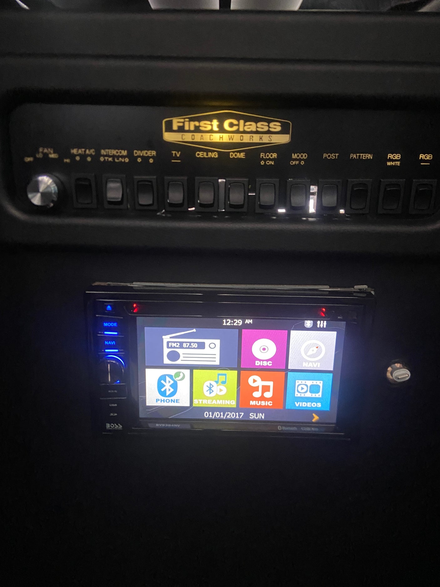 RV rental interior: Illuminated control panel (HVAC, lighting) & BOSS infotainment system with multimedia and navigation.