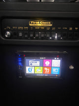 RV rental interior: Illuminated control panel (HVAC, lighting) & BOSS infotainment system with multimedia and navigation.