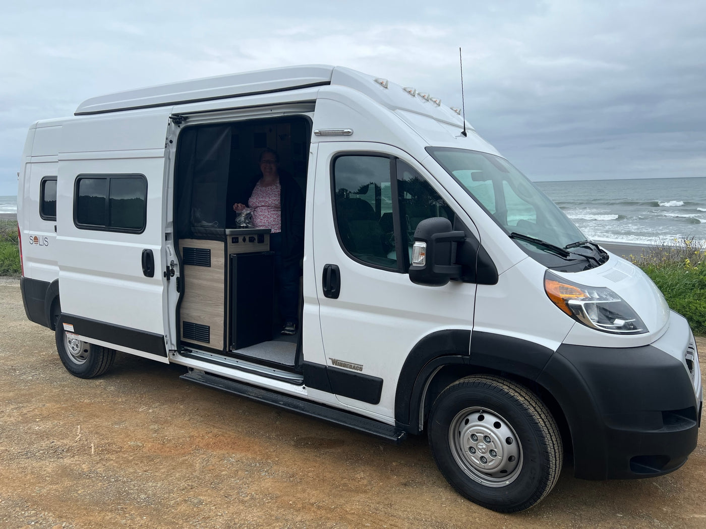  under a dark blue night sky with stars. Perfect for travel!|Woman in a white Winnebago Solis RV rental — photo 2