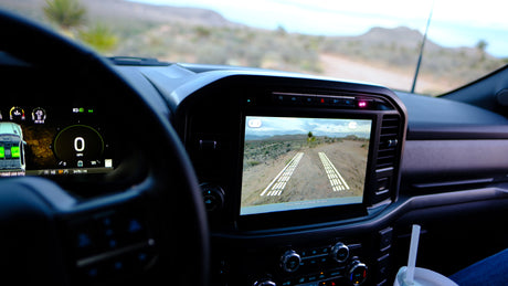 RV rental dash: 0 MPH, camera shows desert off-road path with guide lines. Digital instruments display 51 miles to empty.