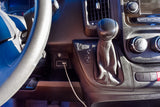 RV rental interior close-up: column shifter with Tow/Haul button, dashboard media/climate controls, and AUX port.