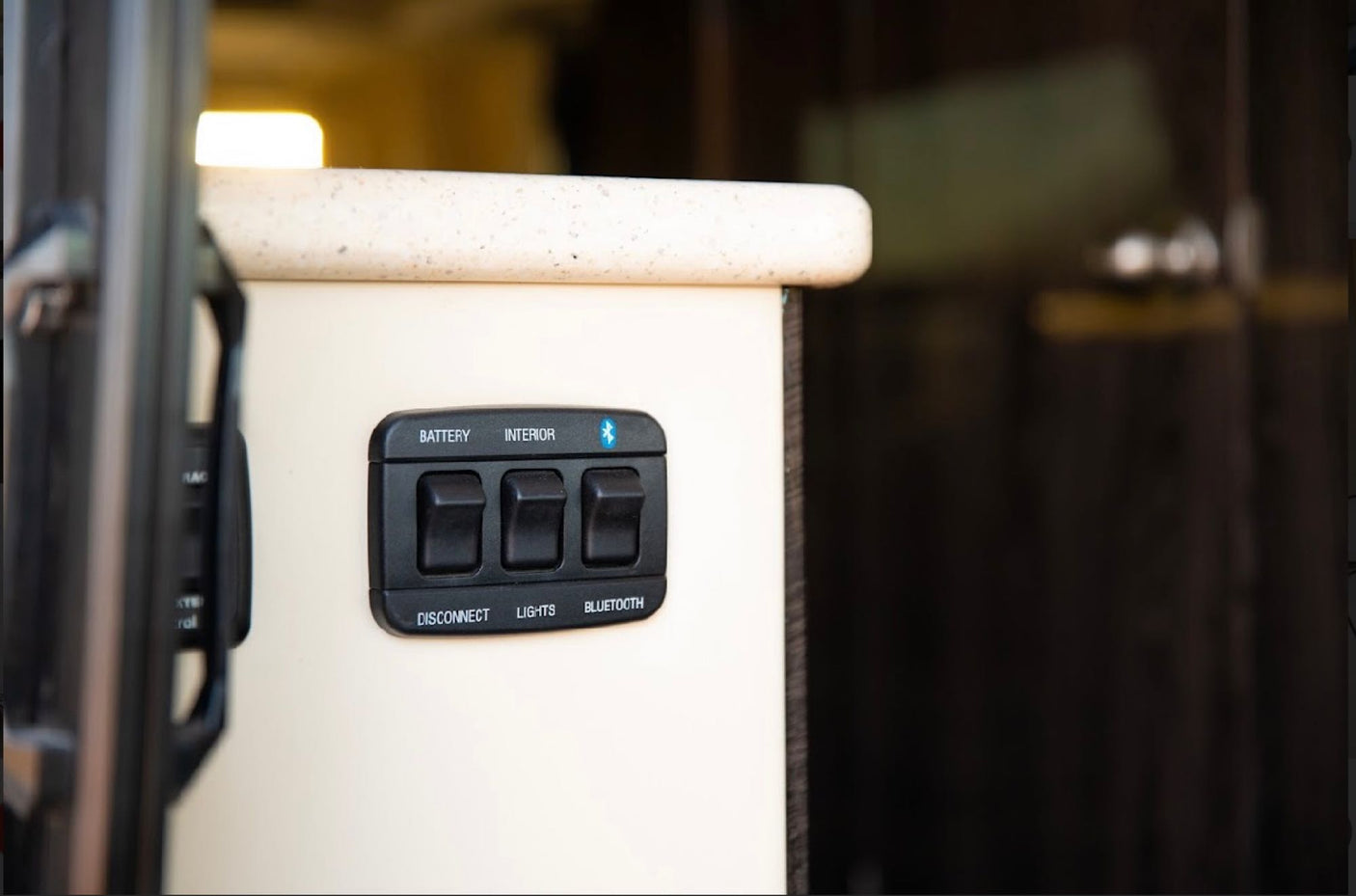 RV rental interior control panel with switches for battery disconnect, interior lights, and Bluetooth connectivity.