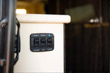 RV rental interior control panel with switches for battery disconnect, interior lights, and Bluetooth connectivity.