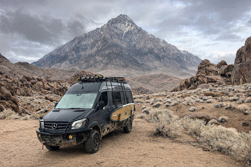  kicks up dust in a dramatic desert landscape with epic mountains and a golden sky.|RV rental interior: organized kitchen with microwave — photo 4