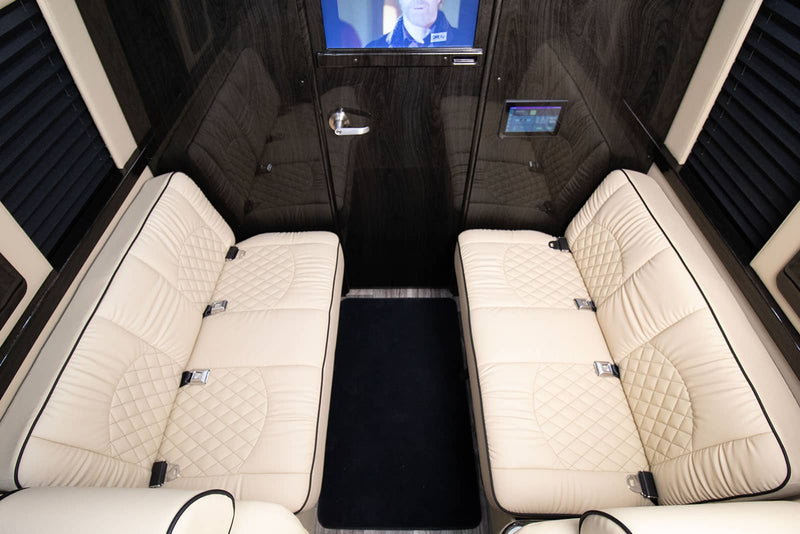  and wood floor.|A smiling woman in white pants & colorful heels sits in a luxurious RV rental van — photo 1