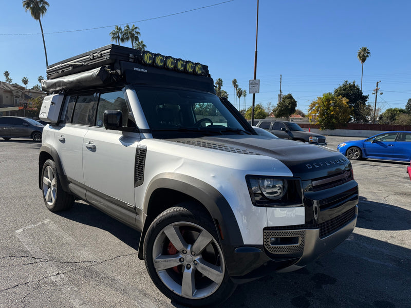 This rugged Land Rover Defender, outfitted with a rooftop tent & KC lights, is perfect for an rv rental outdoor adventure. — photo 8