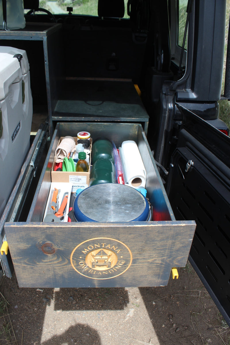 Custom rv rental overlanding setup: a pull-out kitchen drawer packed with camping cooking gear, including a pan, spices, and paper towels. — photo 5