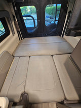 Comfortable RV rental interior featuring convertible seating for a full bed, ideal for road trips.