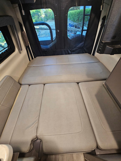 Comfortable RV rental interior featuring convertible seating for a full bed, ideal for road trips.