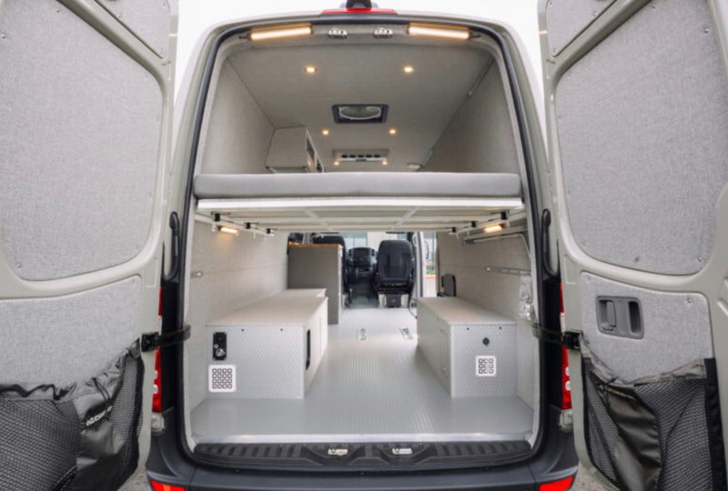 RV rental van conversion: open rear view showing elevated bed, storage boxes, and well-lit interior. — photo 3