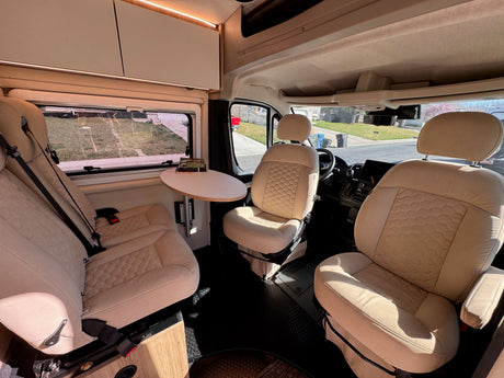 Step inside this inviting rv rental! Features comfortable swivel seats, a small dining table, and modern amenities in a clean camper van.