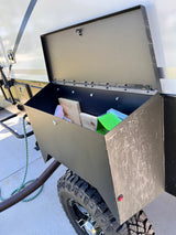 Open utility storage box on an off-road RV rental, holding wood and supplies. Essential for camping and travel.