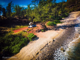 Your next RV rental adventure? White SUV with rooftop tent parked by a beautiful, rocky beach, perfect for camping!