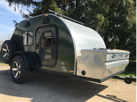 This dark green teardrop camper trailer, featuring diamond plate details, is ready for your next RV rental adventure.