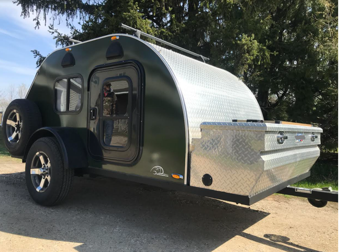 This dark green teardrop camper trailer, featuring diamond plate details, is ready for your next RV rental adventure.